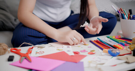 Selective focus, Hands of Young Asian woman sitting on sofa decorating a greeting card in the...