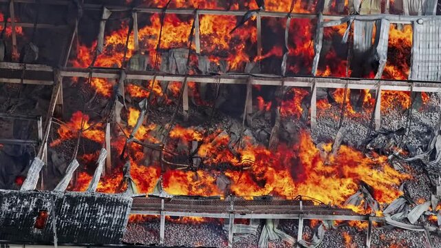Top aerial view of raging flames ravaging a warehouse in industrial area