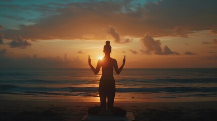 Fototapeta premium Silhouette young woman practicing yoga on the beach at sunrise. 