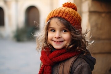 Portrait of a beautiful little girl in a warm hat and scarf