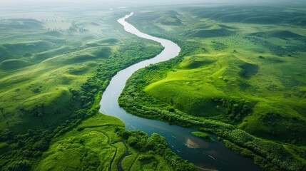 Aerial view of a winding river flowing through lush green hills and valleys.