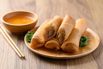 Asian deep fried spring roll filling with cabbage, carrot and glass noodles eating with dipping sauce 
