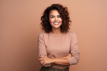 Obraz premium Portrait of a beautiful young woman with curly hair on a brown background
