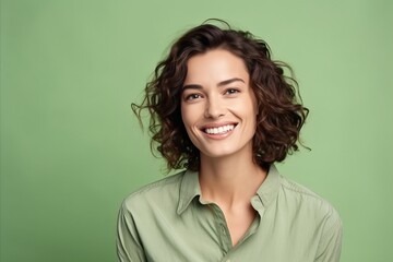 Fototapeta premium Portrait of happy smiling young woman with curly hair, over green background