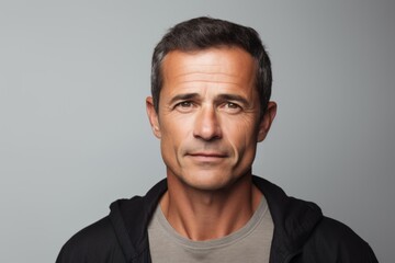 Obraz premium Portrait of a handsome middle-aged man looking at the camera with a serious expression, over grey background