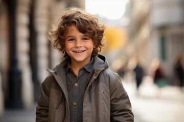 Fototapeta premium Portrait of a cute little boy smiling at the camera in the city