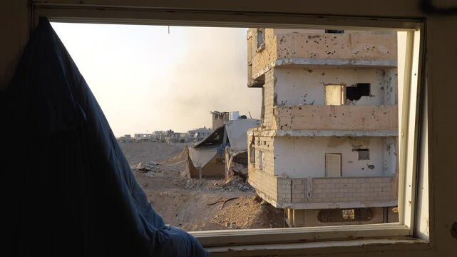 Looking out through broken window to damaged house walls after gunfire in Israel Hamas war conflict
