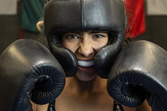 closeup of angry female boxer trained and using mouth guard and face shield