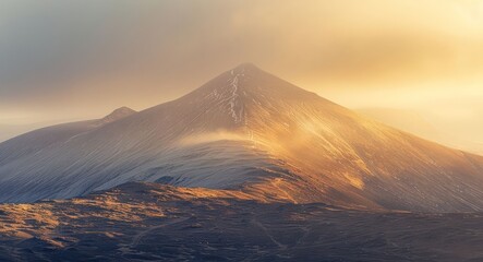 A mountain with snow on it and a cloudy sky