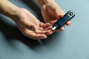 man's hands checking diabetes and hyperglycemia with digital blood sugar meter. Healthcare and medical concept	

