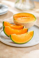 A sweet melon on a plate.
A melon or cantaloupe is a sweet fruit dessert. 
