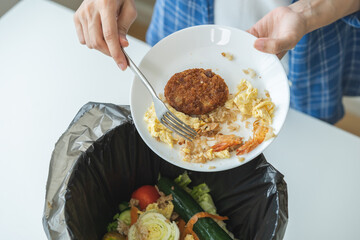 Compost from leftover food, refuse asian young housekeeper woman, girl hand using fork scraping waste from dish, throwing away putting into garbage, trash or bin..Environmentally responsible, ecology.