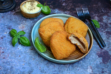  Crispy  deep fried home made     chicken Cordon bleu with cheese   and ham  and french fries on wooden rustic background.  