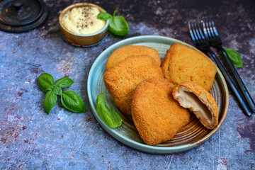  Crispy  deep fried home made     chicken Cordon bleu with cheese   and ham  and french fries on wooden rustic background.  