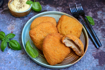  Crispy  deep fried home made     chicken Cordon bleu with cheese   and ham  and french fries on wooden rustic background.  