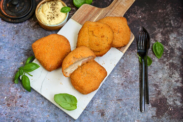  Crispy  deep fried home made     chicken Cordon bleu with cheese   and ham  and french fries on wooden rustic background.  
