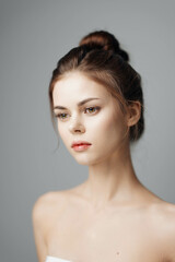 Beautiful young woman with a white towel on grey background, studio shot