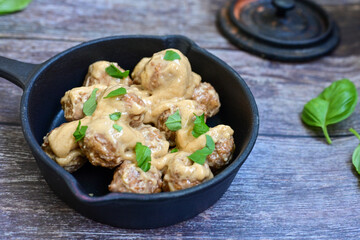 Homemade Swedish Meatballs  With creamy gravy sause in black pan skillet.Swedish cuisine.