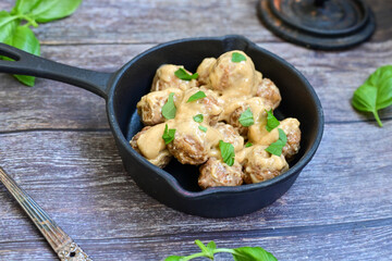 Homemade Swedish Meatballs  With creamy gravy sause in black pan skillet.Swedish cuisine.