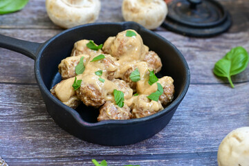Homemade Swedish Meatballs  With creamy gravy sause in black pan skillet.Swedish cuisine.
