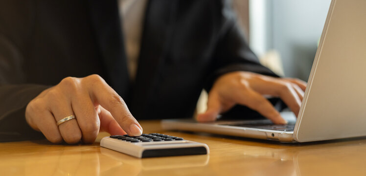 close up accounting employee woman hand pressing on calculator for calculate about monthly profit of business for senior accountant job working concept - Powered by Adobe