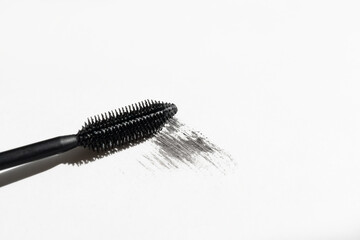 Black mascara with mascara brush on white background