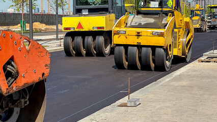 Rollers roll or lay new or fresh asphalt