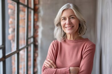 Fototapeta premium Portrait of confident smiling middle aged woman with crossed arms