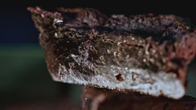 Close up of glossy stone mineral on a blurred background. Stock footage. Natural resources concept.