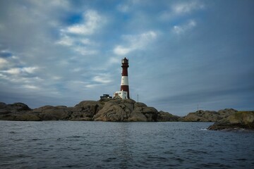 View of a lighthouse on a rocky coastline under a blue sky