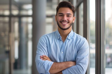 portrait of young male executive standing with crossed arms dressed in casual clothing