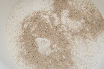 Suche drożdże wsypane do mąki w misce, widok z gory