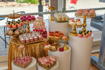 Empty Wedding Reception Dessert Table With Pink and Gold Decorations