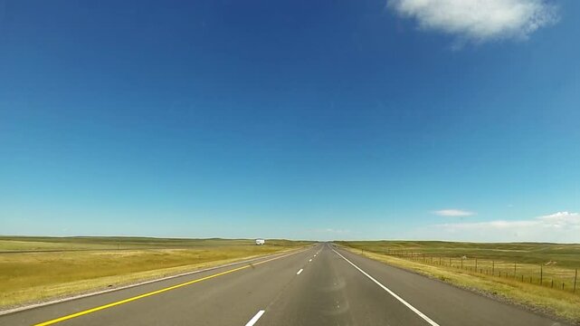 Driving point-of-view traveling on empty Wyoming highway.