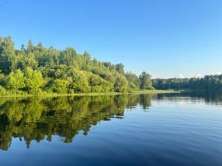 Obraz premium beautiful lake on the shore forest with reflection in water blue sky in reflection of water.