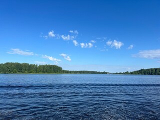 full after the boat on the river and the surface of the water with the reflection of the blue sky in the water.