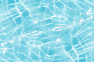 Blue water with ripples on the surface. Defocus blurred transparent blue colored clear calm water surface texture with splashes and bubbles. Water waves with shining pattern texture background.