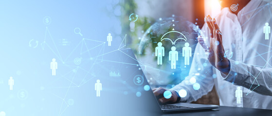 Businessman using internet on laptop with icons on holographic screen, network connections, and concepts. Blurred background. Business network concept