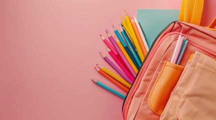 Fototapeta premium Close-up photo of colorful pencils spilling out of a stylish school bag against a soft pink background