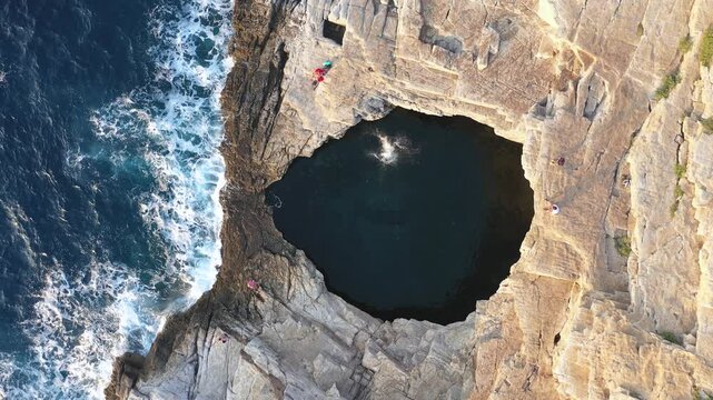  Aerial slow motion view of woman jumping into water Giola sea pool, lagoon. Thassos island, Greece