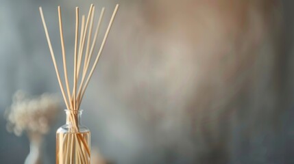 Close-up of reed diffuser in a glass bottle with blurred background, creating a serene and aromatic home decor atmosphere.
