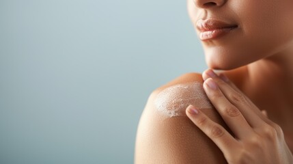 Close-up of woman applying moisturizer to her shoulder, highlighting skincare routine for smooth and healthy skin.
