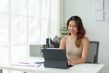 Asian businesswoman or executive manager using laptop computer is checking data, typing, searching, financial records, statistics, taxes, income in online business in office.