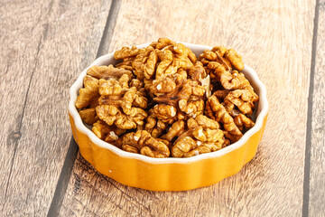 Cracked unshelled walnut in the bowl
