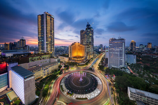 Jakarta, Indonesia - September 12, 2022: Jakarta skyline taken in a fantastic blue hour, with the big roundabout that hold the iconic welcome monument and the skyscrapers in the background under the b