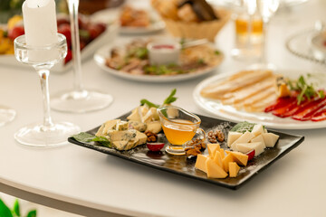 cheese plate Assortment of different types of cheese with grapes and nuts on a banquet table
