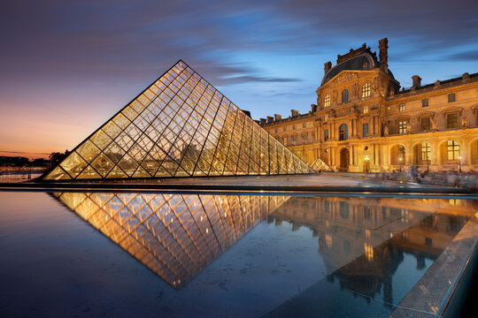 Paris, France - July 29, 2019: The Louvre museum, one of the most important museum in the world, taken at dusk with the iconic pyramid reflected in the fountain, Paris, France