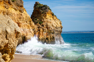 View of idyllic nature landscape with rocky cliff shore and waves crashing on. Camillo beach in...