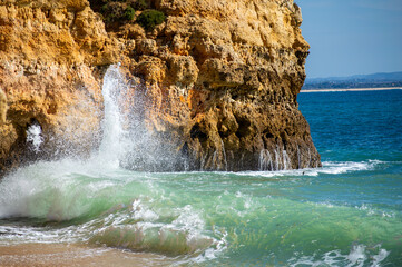 View of idyllic nature landscape with rocky cliff shore and waves crashing on. Camillo beach in...