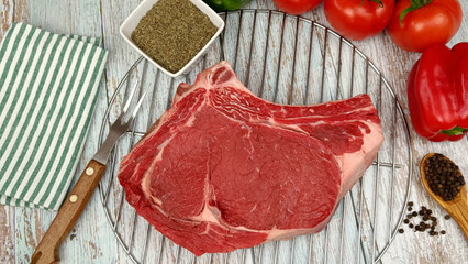 côte de boeuf cru, en gros plan, sur une grille à barbecue